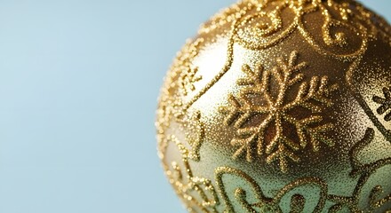 Close-up of a shimmering golden Christmas ornament with intricate snowflake patterns, perfect for festive holiday season decorations
