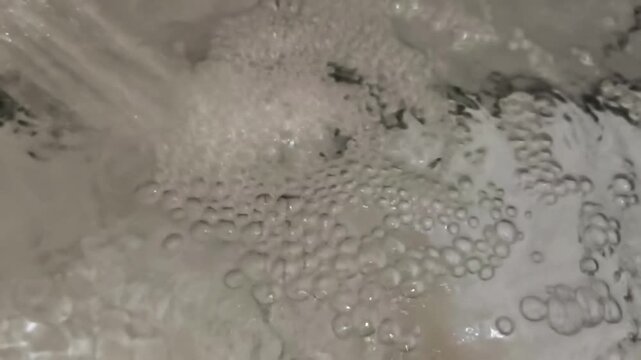 The water gushed out, creating lots of small bubbles.