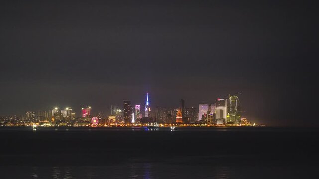 Timelapse of the dawn and the sunrise over the modern city skyline of Batumi, Georgia. Black Sea coast and iconic architecture as the city lights dim and the natural light of the morning brightens