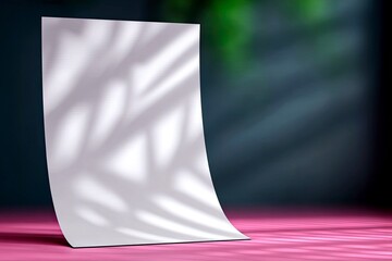 A blank white sheet of paper is illuminated by studio lighting, casting palm leaf shadows onto its surface and a vibrant pink floor.