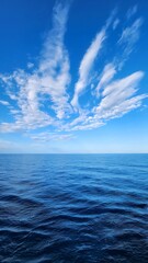 Fototapeta premium Calm Blue Sea and Sky with White Clouds on the Horizon