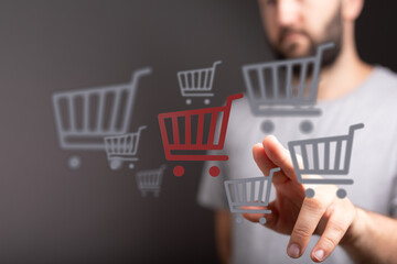 Person interacting with shopping carts, representing online retail, e-commerce, digital shopping,...