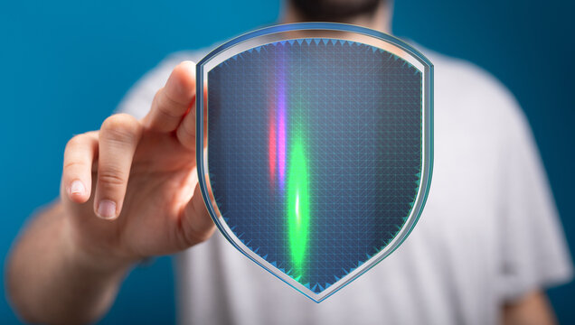 Hand touching digital shield with colorful lights, representing data protection, cybersecurity and online security. Concept for data