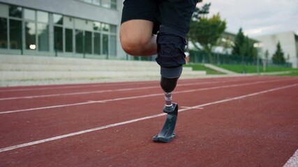 Man with a running prosthesis, a prosthetic leg with a blade, training on an athletic track, slow motion. Disabilities and active lifestyle concept. - Powered by Adobe