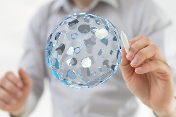 Close-up of a man's hand drawing a digital sphere with connected icons representing network, global connection, digital transformatio