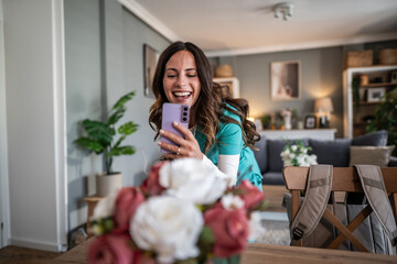 Happy nurse video calling on smartphone at home