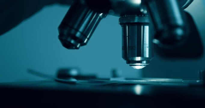 Laboratory optical microscope macro view with gloved hands