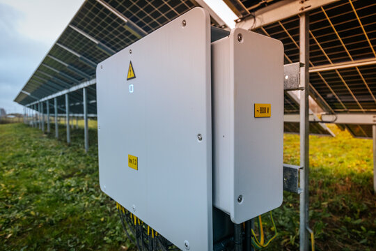 solar inverter labeled 800V, installed under a ground-mounted solar panel array in a grassy field, used for energy conversion.