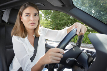 Naklejka premium serious woman driving car looking through the window