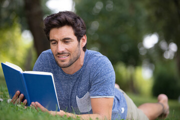 young man reading book in the park