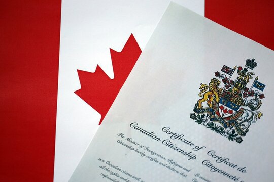 Canadian certificate of citizenship on Canadian flag close up