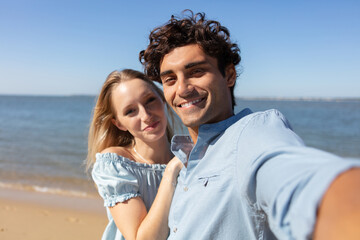 Fototapeta premium pretty young loving couple taking selfie together on smartphone