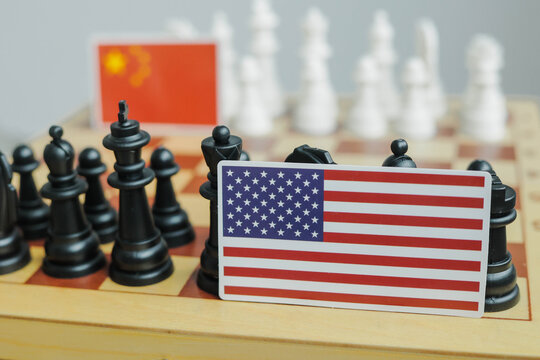 Flag of USA and a Chinese flag on chessboard. Tariffs war and conflict between those two countries.