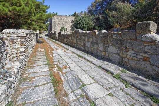 Paved road, Via Cardo, built 3rd century BC, made of local amygdalo stone, a type of travertine, with traces of the former vehicles, back right nymphaeum, Greek nymphaion, Latin nymphaeum, western excavations, city of Kos, island of Kos, Dodecanese islands, Greece