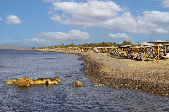 Parasol, sun lounger, sea, pebble beach, piled up with sand, people on the beach, Hotel Mitsis Ramira, Psalidi region, Kos island, Dodecanese Islands, Greece