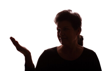 Dark silhouette elderly woman, pensioner points hand to side - isolate