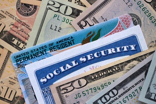 Social security number and permanent resident card with US dollar money bills close up - Powered by Adobe