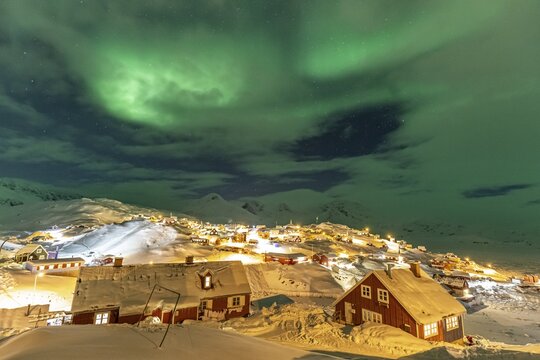 Northern Lights, Aurora borealis over houses, Inuit settlement, Winter, Tasiilaq, East Greenland, Greenland