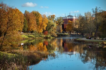 Scenic autumn landscape with colorful trees reflecting in calm water under blue sky