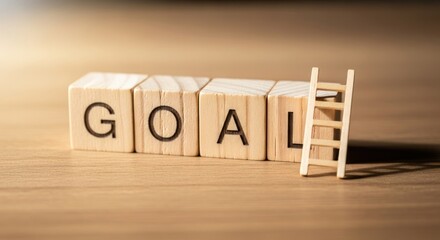 Wooden blocks spell goal next to a small ladder on table.