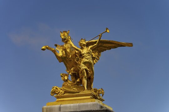 Column with the group of figures Fama of War on the Pont Alexandre III bridge over the Seine, Paris, France