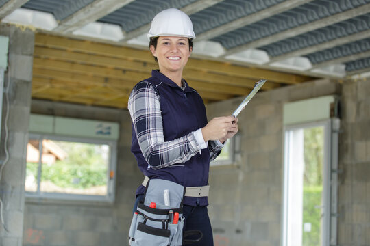 smily woman builder holding a clipboard
