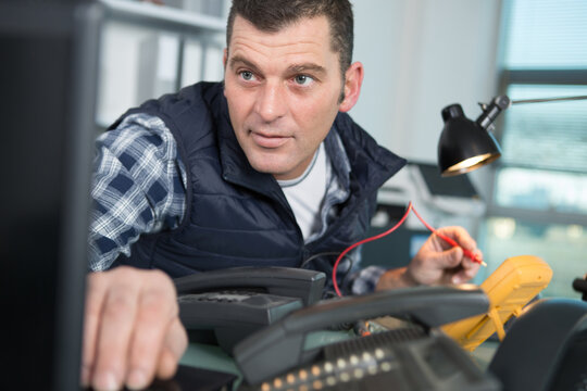 repairman changing broken smartphone screen in service center