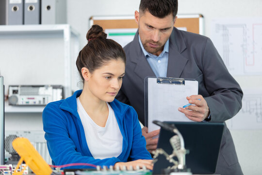 woman with a tester and a printed circuit board