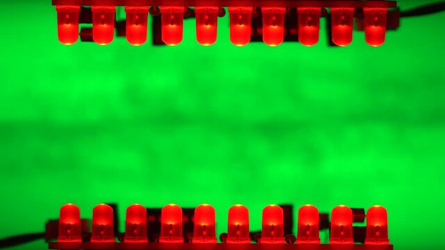 Two rows of red LEDs face each other over a green field, forming a mirrored runway of light. Copyspace.