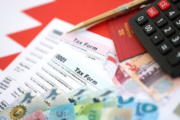 Bahraini dinar money bills and calculator with tax form on flag close up. Taxation and accounting concept