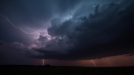 Dramatic lightning strikes illuminate a powerful thunderstorm over a dark, silhouetted landscape creating a breathtaking natural spectacle.