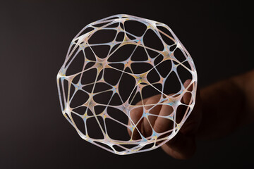 Intricate network sphere held gently. Representing concepts such as connection, innovation, and technological advancements.