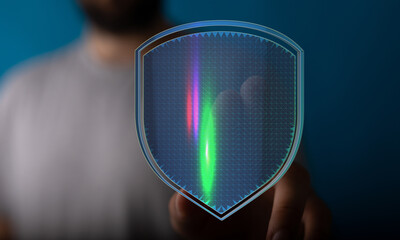 Concept of cybersecurity and data protection. Hand touching a digital shield, representing...