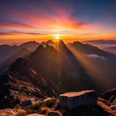 Sun rays burst over the jagged peaks of the mountains at colorful sunrise