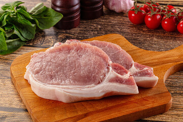 Raw pork steak over board