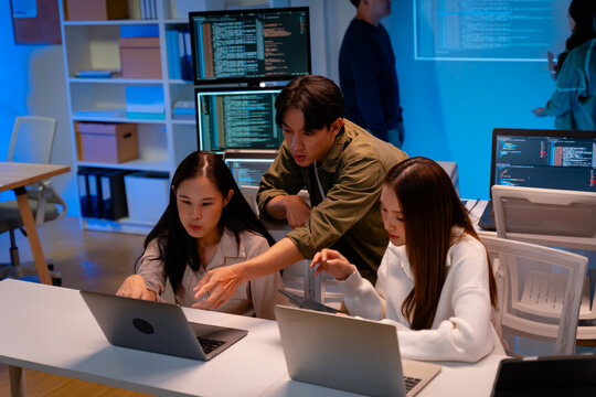 Asian software engineer or programmer team working late in development office,problem solving or algorithm of ai assistant helping for work.software developer,digital technology security concept