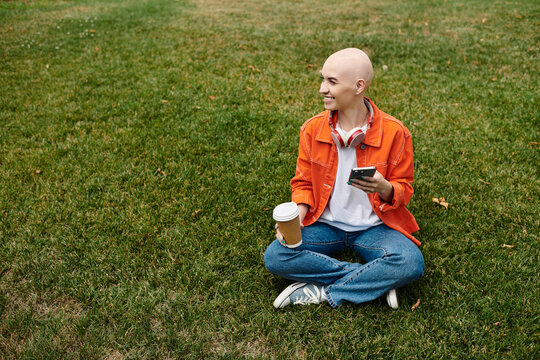 Bald woman enjoying a sunny day outdoors in a vibrant orange denim jacket