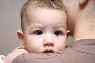 Pretty young mother holding her newborn baby boy. close up
