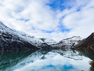 A winter landscape along the Sognefjellsvegen road in Norway, featuring snow-covered mountains and a vast, serene terrain.
