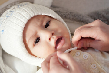 A mother dressing her little baby boy boy at home. childhood parenthood and growing up family...