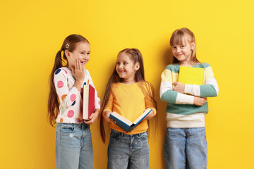 Cute kids with books on orange background