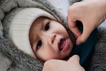 A mother dressing her little baby boy boy at home. childhood parenthood and growing up family...