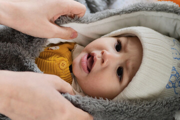 A mother dressing her little baby boy boy at home. childhood parenthood and growing up family...