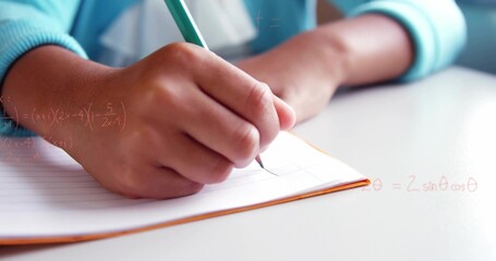 Writing student hand moving across ruled pad orange-edge white desk, green pencil, teal top, math © vectorfusionart