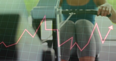 Rowing woman wearing sports bra and leggings on rower at home gym, showing grid magenta graph