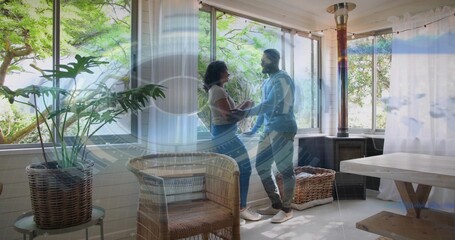 Holding hands man in blue hoodie, woman in white top standing on sunroom ledge, with HUD