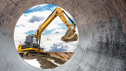 Heavy machinery operates at a construction site as seen through a circular pipe. The excavator skillfully raises its bucket against a backdrop of clouds and earth