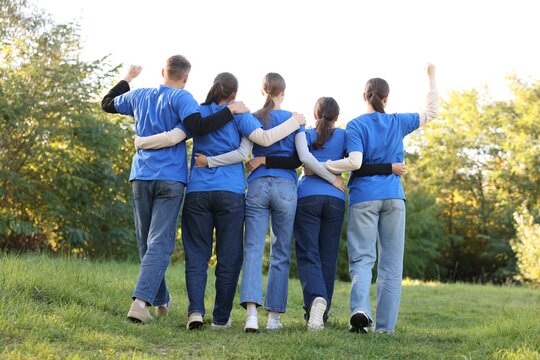 Group of volunteers together in park, back view