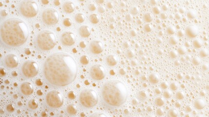 Close-up of frothy beer bubbles creating a textured surface, with soft lighting enhancing the creamy foam