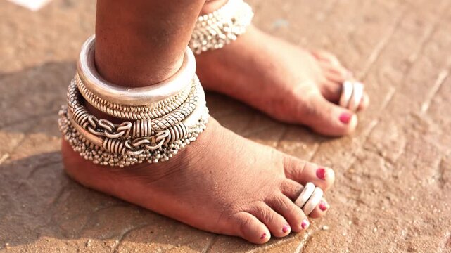 Close-up of an Indian woman&rsquo;s feet with silver anklets and toe rings, symbolizing traditional Indian customs and feminine grace.